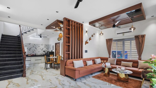 Uma sala de estar moderna com piso de mármore, um conjunto de sofás, uma área de refeições e uma escada.