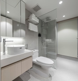 A modern bathroom with a white sink, toilet, and shower. - Little Charm Boutique Hotel (Ba Đình)