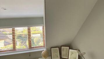 A room with a white desk, a globe, and framed pictures.