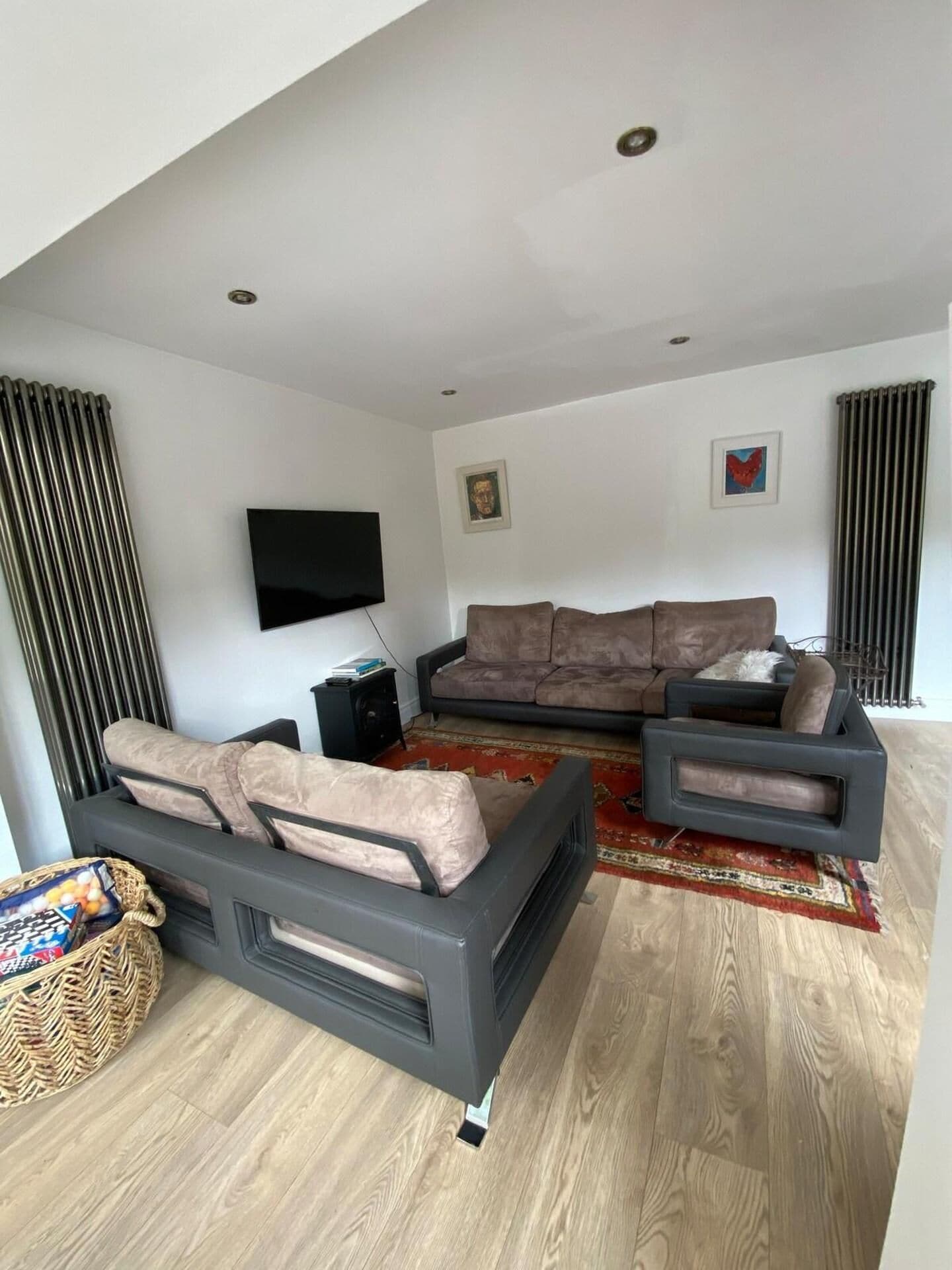 A modern living room with a sofa, a coffee table, and a flat-screen TV mounted on the wall.