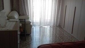 Une chambre à coucher avec un lit, une table de chevet avec une lampe, une chaise et une armoire.