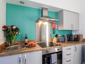 Una cocina con campana de acero inoxidable, un fregadero, un tostador y un microondas.