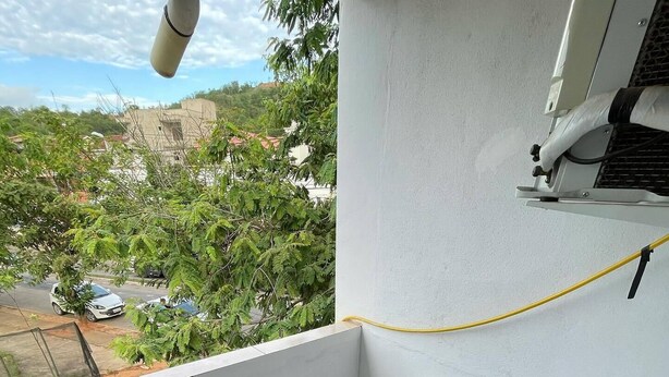 Un balcón con vista a una zona residencial, una mesita y una silla.