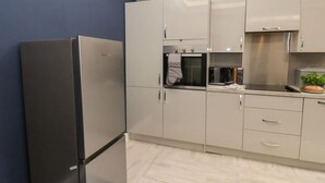 Eine moderne Küche mit Einbauofen, Mikrowelle und Kühlschrank.