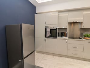 A modern kitchen with a built-in oven, microwave, and a refrigerator. - Frankies Seaview 2 (Bridlington)