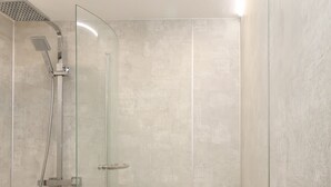 A glass-enclosed shower with a handheld showerhead and a handheld hose. - Frankies Seaview 4 (Bridlington)