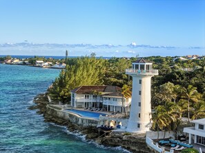 Ein Küsteneigentum mit Leuchtturm, Schwimmbad und einer Terrassenfläche.