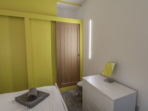 A bedroom with a bed, a dresser, a mirror, and a door. - Frankies Seaview 3 (Bridlington)