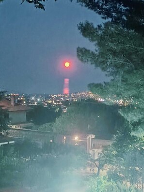 A nighttime view of a cityscape with a prominent tower emitting a red light.