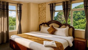 A large bed with a wooden headboard, a bedside table, and curtains. - Heritage Rose Inn - Dal Lake (Srinagar)