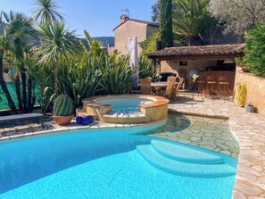 Ein Pool mit Stufen, umgeben von Blumentöpfen und Gartenmöbeln.