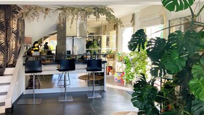 A spacious living area with a kitchen, dining area, and a staircase leading to an upper level. - Villa for 7 guests with private pool and hot tub near Cannes (Fréjus)