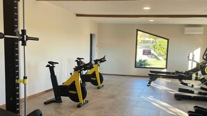 A gym with exercise bikes, treadmills, and a squat rack. - Mobil home for 6 guests – Gulf of Saint-Tropez 4★ (La Garde-Freinet)