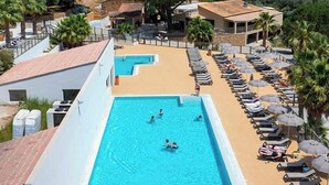 A swimming pool with sun loungers and umbrellas, surrounded by buildings and trees. - Mobil home for 6 guests – Gulf of Saint-Tropez 4★ (La Garde-Freinet)