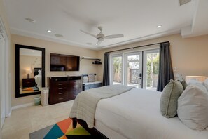 A bedroom with a bed, a dresser, a mirror, a ceiling fan, and a view through a sliding glass door. - South Mission Sand & Surf Retreat with AC & 3 Car Garage! (San Diego)