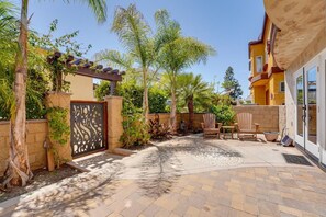A courtyard with a patio, outdoor seating, and a gate. - South Mission Sand & Surf Retreat with AC & 3 Car Garage! (San Diego)