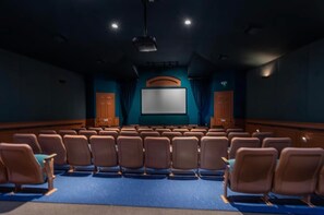 A theater with rows of seats, a large screen, and wooden paneling. - Windsor Palms Condo - Resort Pool, Hot Tub- Near Disney (Kissimmee)