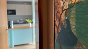 Une cuisine moderne avec des meubles de couleur bleu clair, un four à micro-ondes et un vase rempli de fleurs.