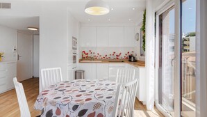 Eine moderne Küche mit weißen Schränken, einer Holztischplatte und einer gemusterten Tischdecke.