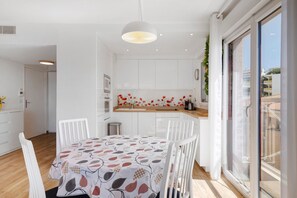 Eine moderne Küche mit weißen Schränken, einer Holztischplatte und einer gemusterten Tischdecke.