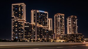 Un ensemble d’immeubles de grande hauteur doté d’une signalétique lumineuse, de nombreux étages et d’une architecture moderne.