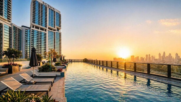 Une piscine à débordement située sur le toit, agrémentée de chaises longues et de plantes en pot, offrant une vue imprenable sur le panorama urbain au coucher du soleil.