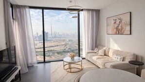 Un salon moderne avec une grande fenêtre, un canapé, une table basse et un téléviseur.