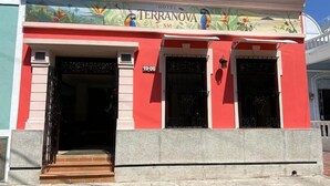 A hotel named 'Terranova' with a colorful mural, a red facade, and a visible entrance. - Hotel Terranova SM (Santa Marta)