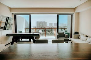 A modern living room with a pool table, a sofa, and a balcony with a city view. - Spacious 3BR w/ Terrace in La Isla Acapulco (Acapulco de Juárez)
