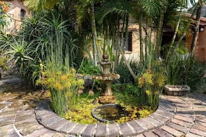 A garden with a stone fountain, lush greenery, and a brick pathway. - Peaceful Nature Retreat in Magical Tepoztlán (Tepoztlán)