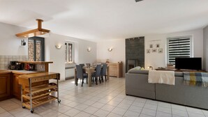 Une cuisine moderne avec un coin repas, un canapé et un téléviseur.