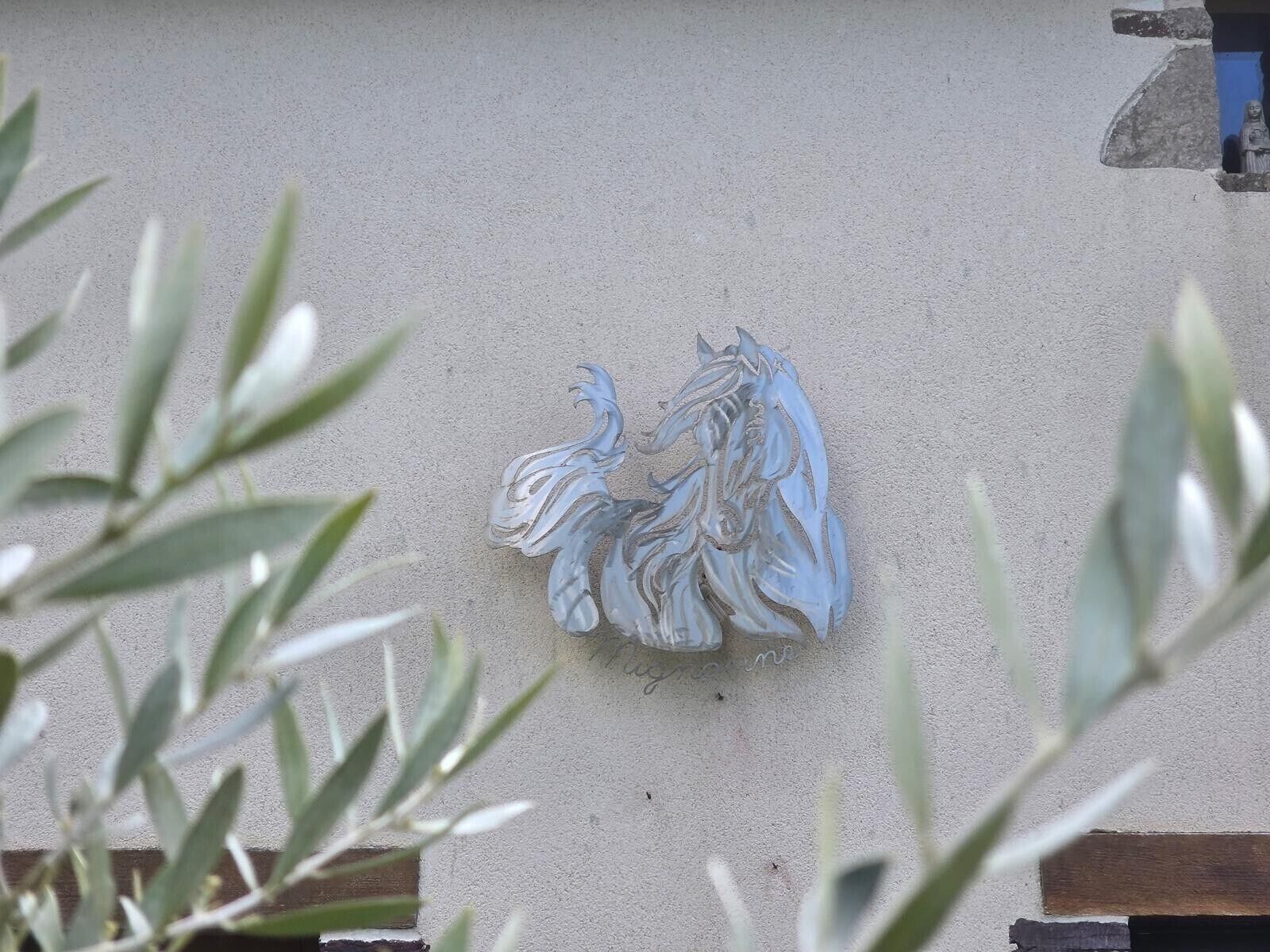 Une sculpture équestre fixée au mur.