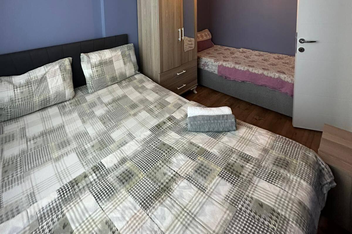 Un dormitorio con una cama, un armario, una mesita de noche, una lámpara y una puerta.