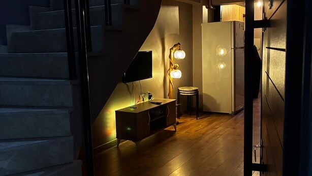 Ein modernes Interieur mit einer Treppe, die zu einer Küche, einem Esstisch und einer Bar führt.