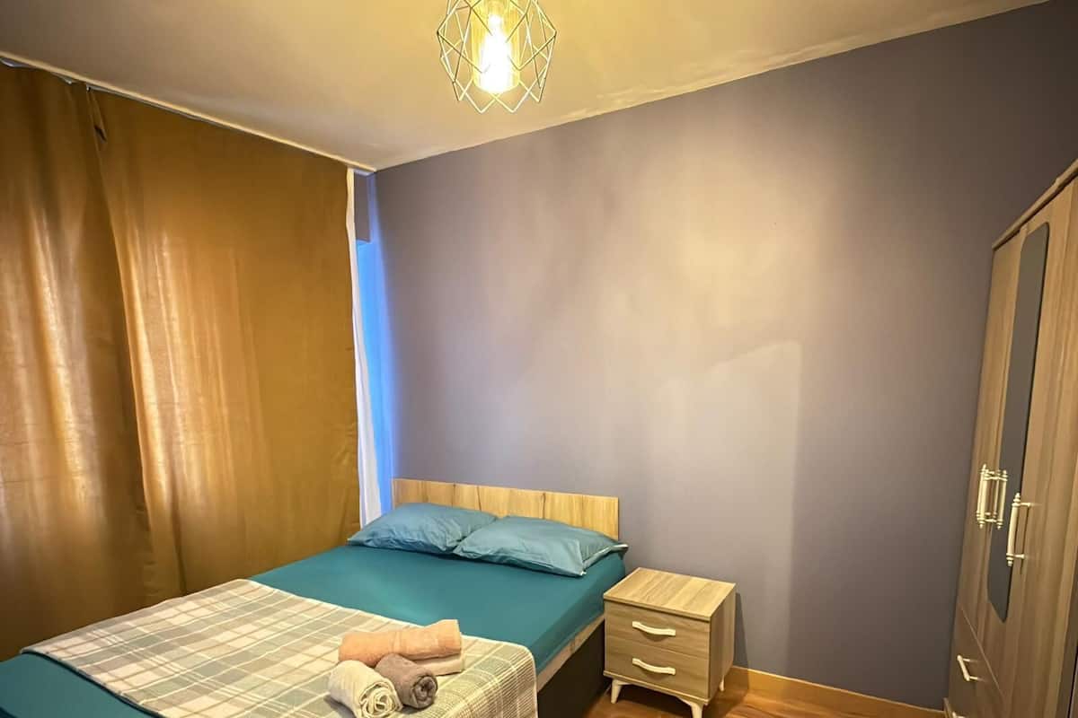 Un dormitorio con cama, mesita de noche y armario.