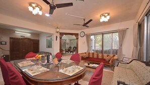 A dining area with a round table, red chairs, and a ceiling fan.
