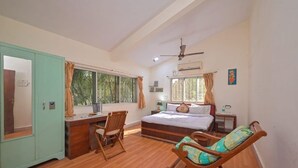A bedroom with a bed, desk, chair, and wardrobe.