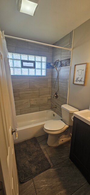 A bathroom with a bathtub, toilet, and shower. - Amazing 5-bedroom house with huge deck on corner lot (Warren)