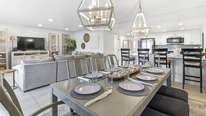 Une cuisine moderne avec un coin repas, un canapé et un téléviseur.