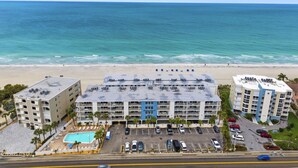Un hôtel situé en bord de mer, avec plusieurs étages, un parking et une piscine.