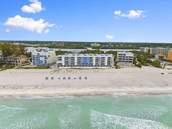 A beachfront hotel with multiple buildings, a sandy beach, and a view of the ocean. - Holiday Villas 2 Unit 206 (Indian Shores)