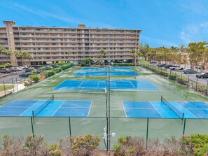 Hotel de diverses plantes amb un complex esportiu de tennis.