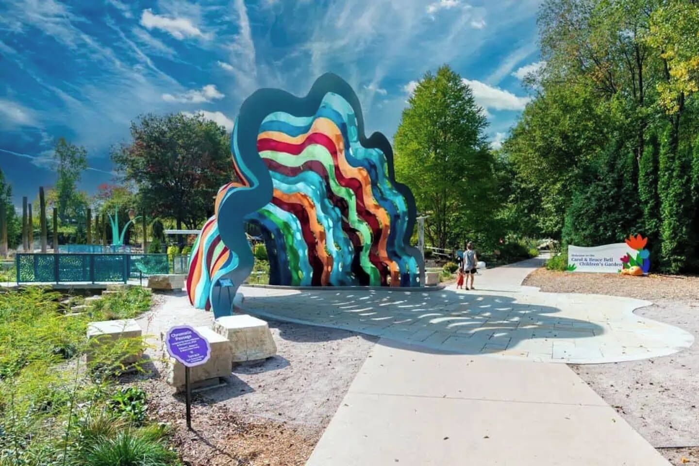 A colorful abstract sculpture in a park setting.