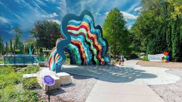 A colorful abstract sculpture in a park setting.