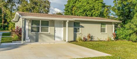 A single-story house with a front porch, a driveway, and a well-maintained lawn.