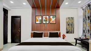 Quarto de hotel com uma cama grande, cabeceira de madeira, obra de arte na parede, cortina e uma pequena mesa com xícara e pires.