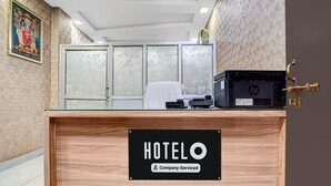 Balcão de recepção de hotel com placa indicando serviço para empresa.