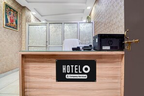 A hotel reception desk with a sign indicating it is company-serviced. - Classic Rainbow Gold Inn (Lucknow)