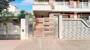 A gated entrance with a metal gate and a brick wall. - Classic Rainbow Gold Inn (Lucknow)