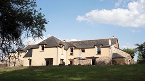 A two-story house with a stone facade, multiple windows, and a grassy yard. - La Hulotte en Brocéliande - Yoga, seminars & group holidays 15 pers. (Saint-Malon-sur-Mel)